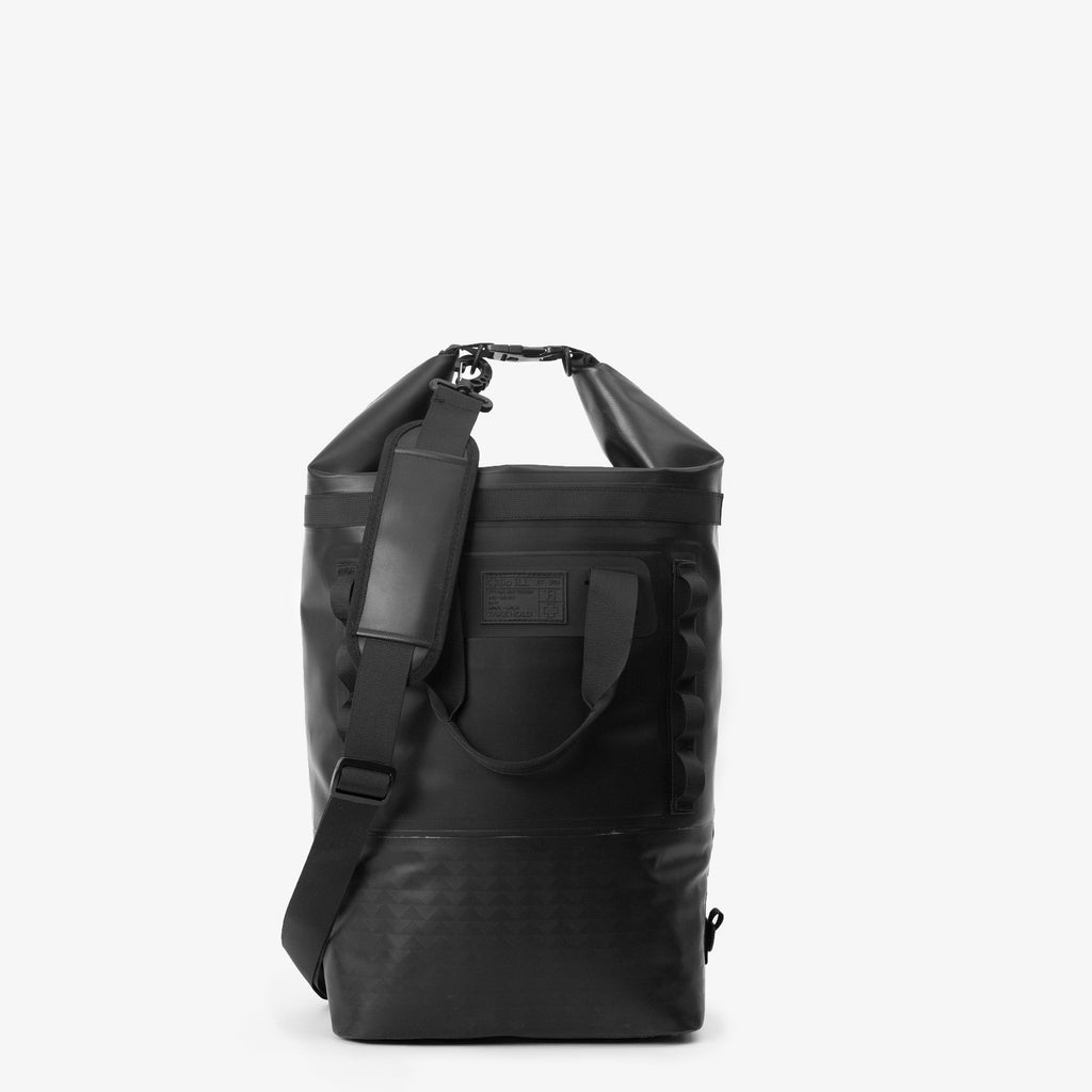 the front of a black 25L so ill x on the roam dirt bag is shown  rolled down to be waterproof - on a grey background